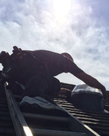 Solatube installer installing roof dome from a ladder