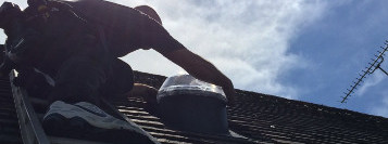 Solatube installer installing roof dome from a ladder