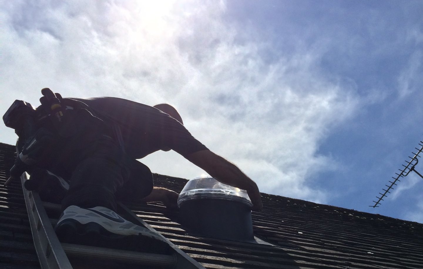 Solatube installer installing a roof dome from a ladder